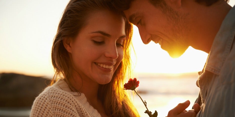 woman and man touching foreheads in sunset