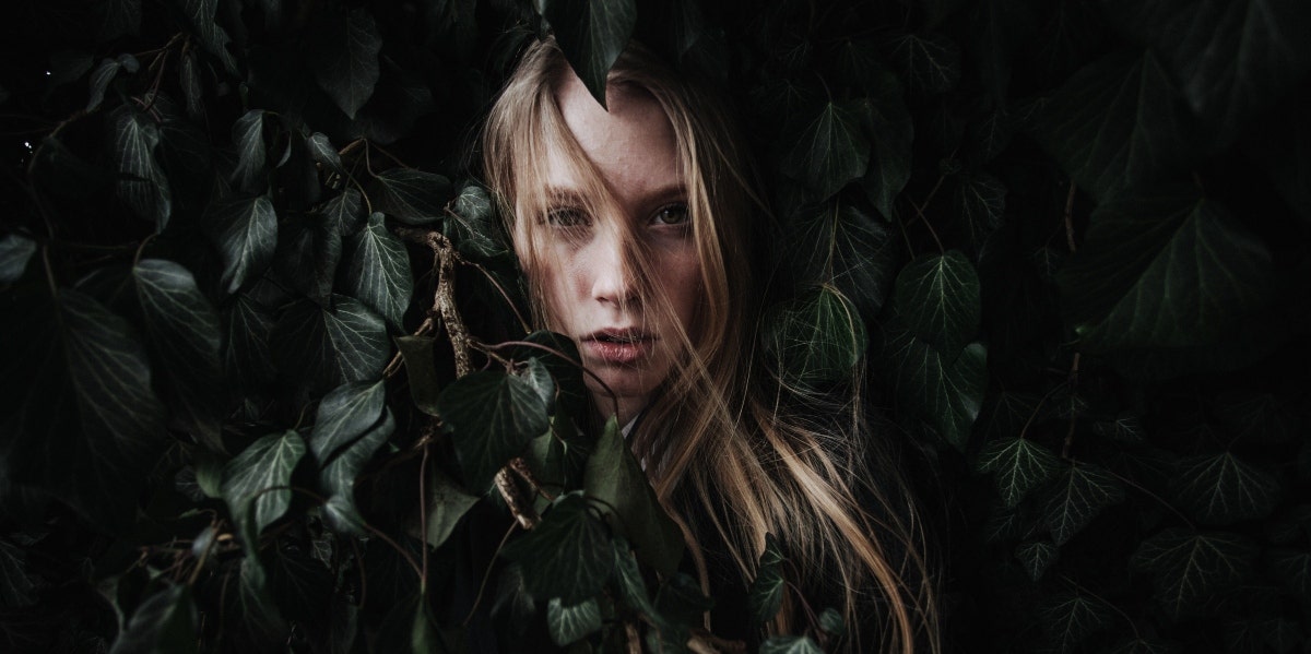 woman covered in green leaves