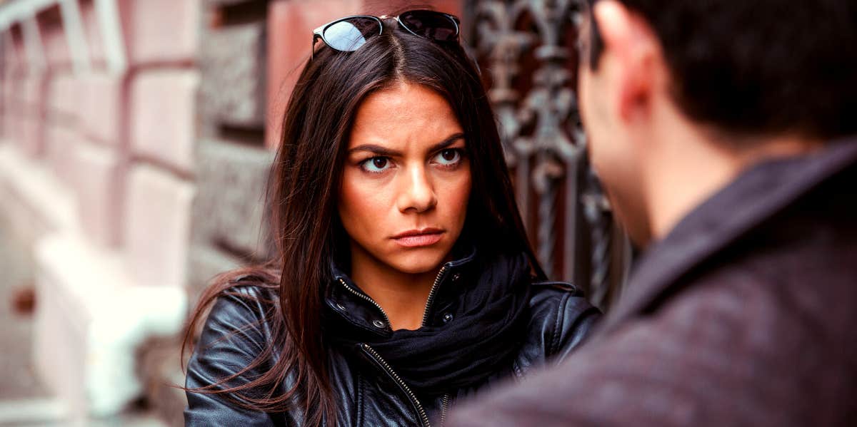 woman looking at her boyfriend as they fight