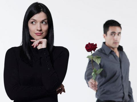 man offering rose to woman