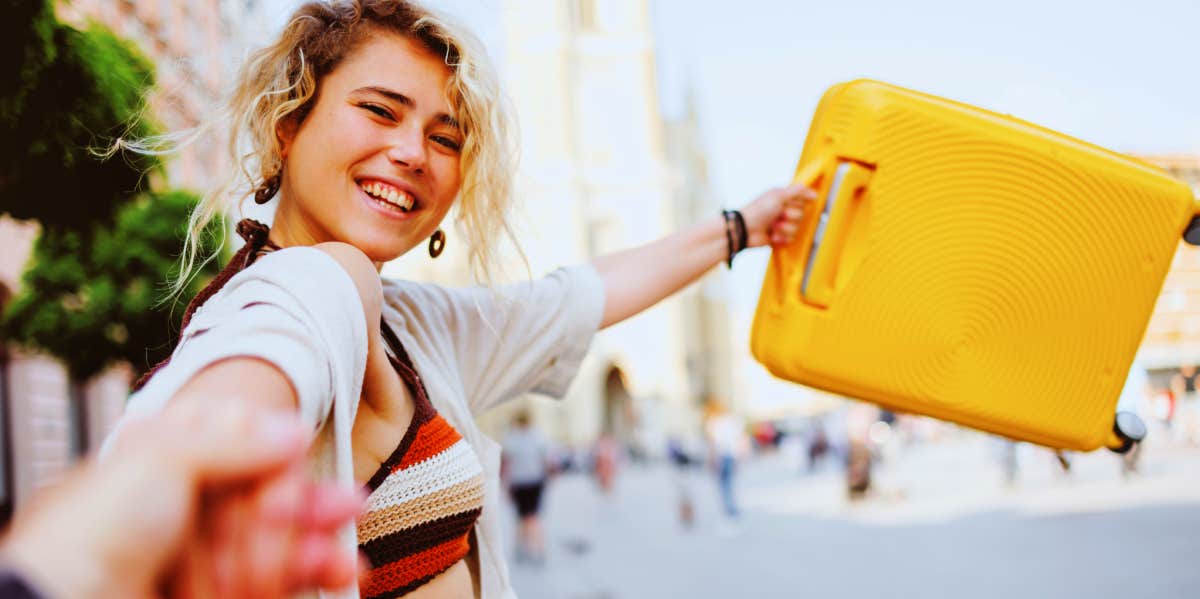 happy girl holding suitcase traveling