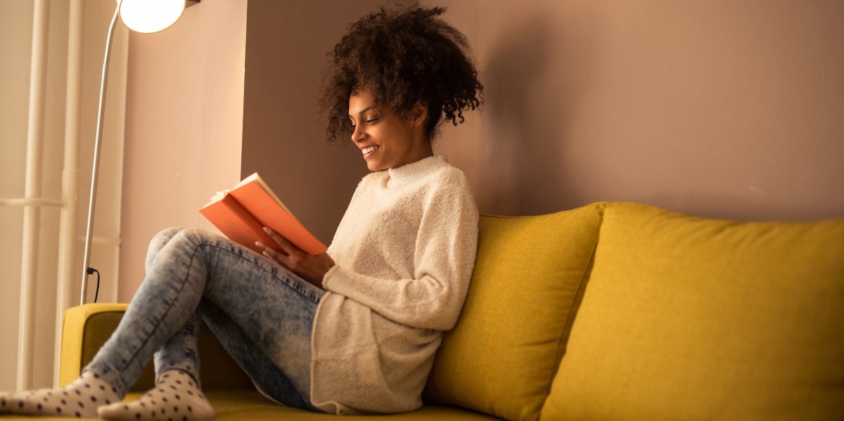 woman reading journal on the couch