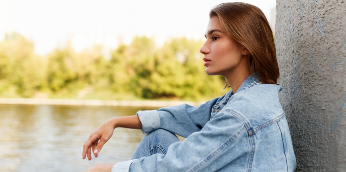 woman sitting near lake