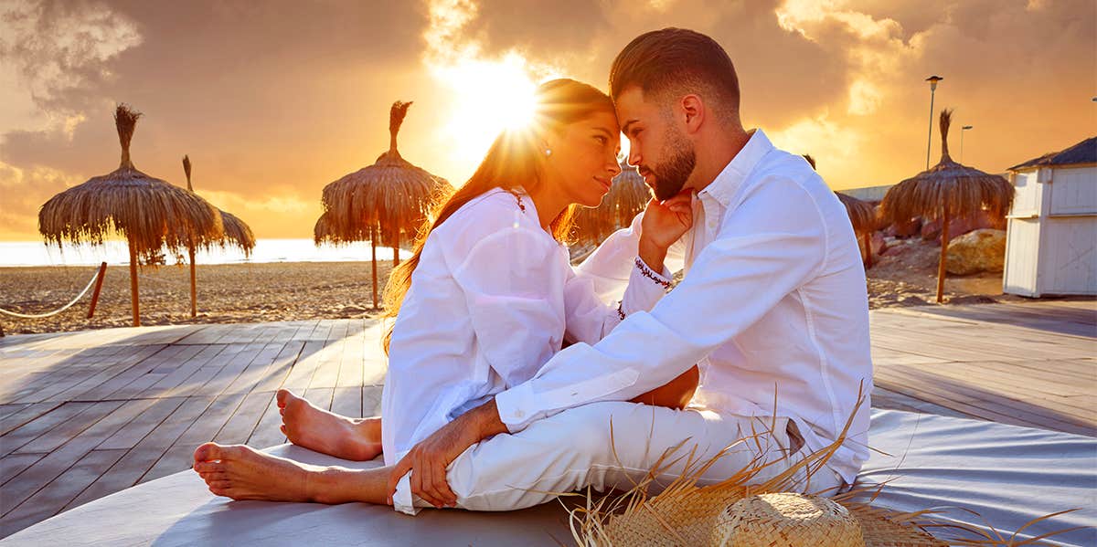 couple sitting in the sunset on honeymoon