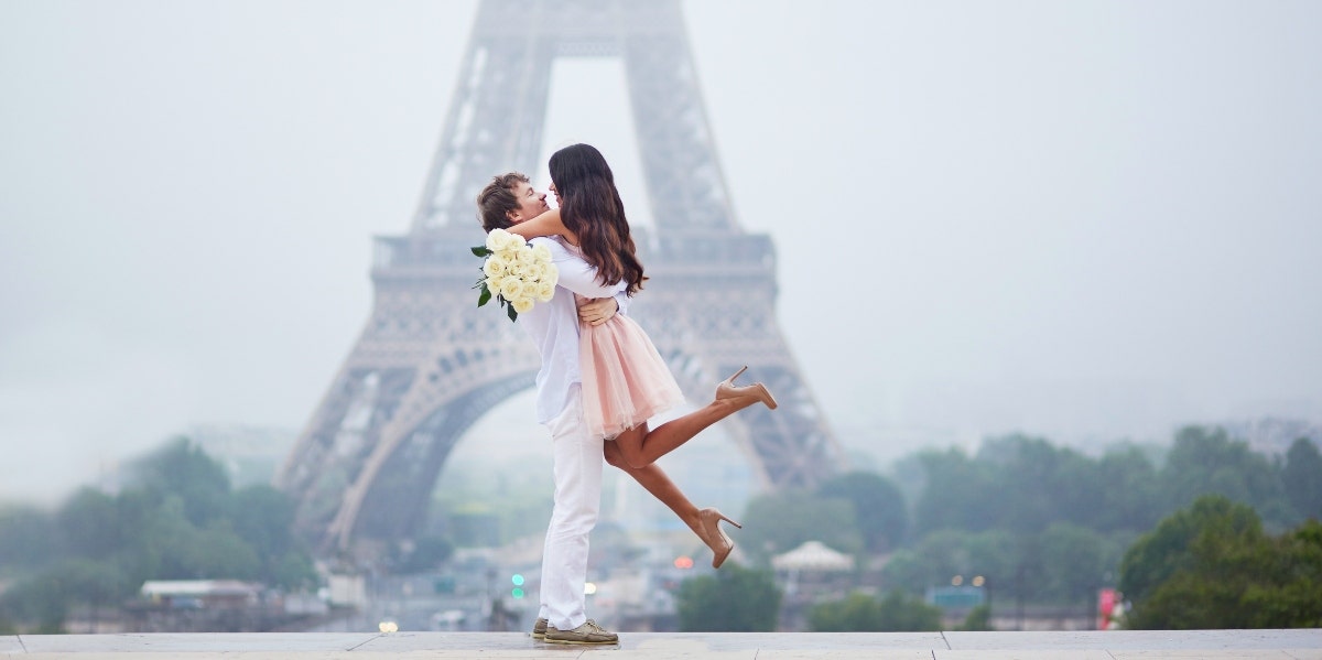 keeping a long-term relationship alive man with woman in his arms in front of the Eiffel tower