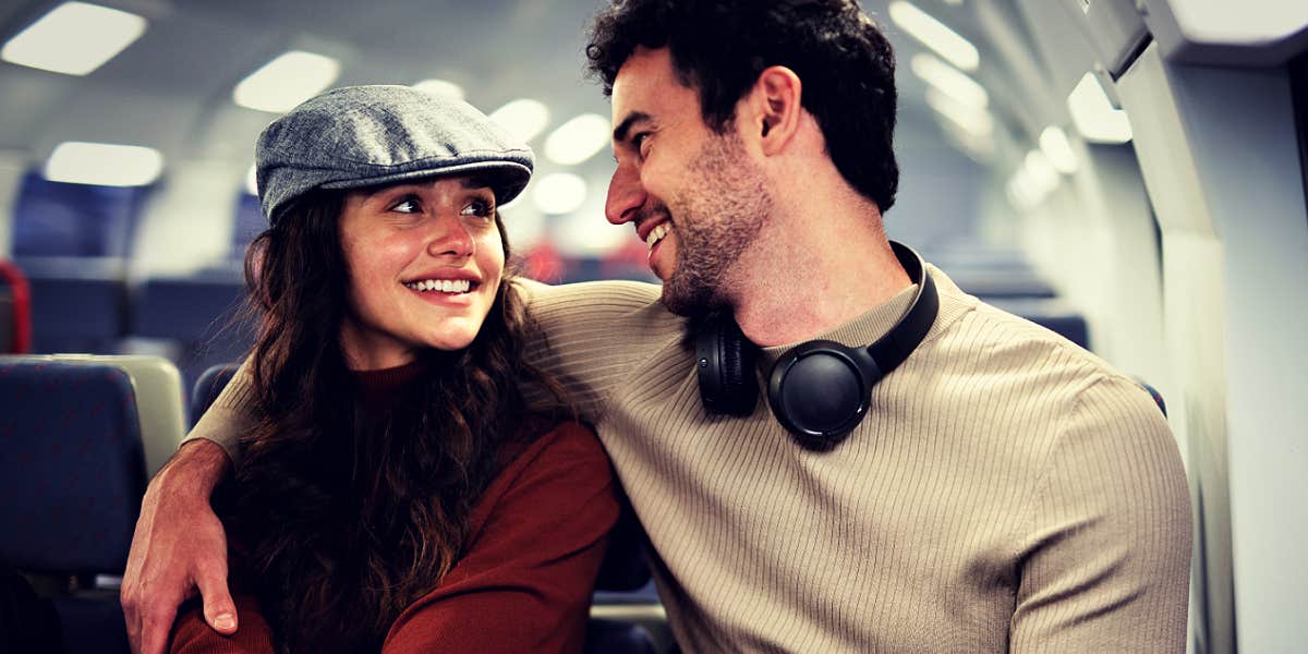 Ingredient for relationship-building young brunette couple smiling at one another on a train