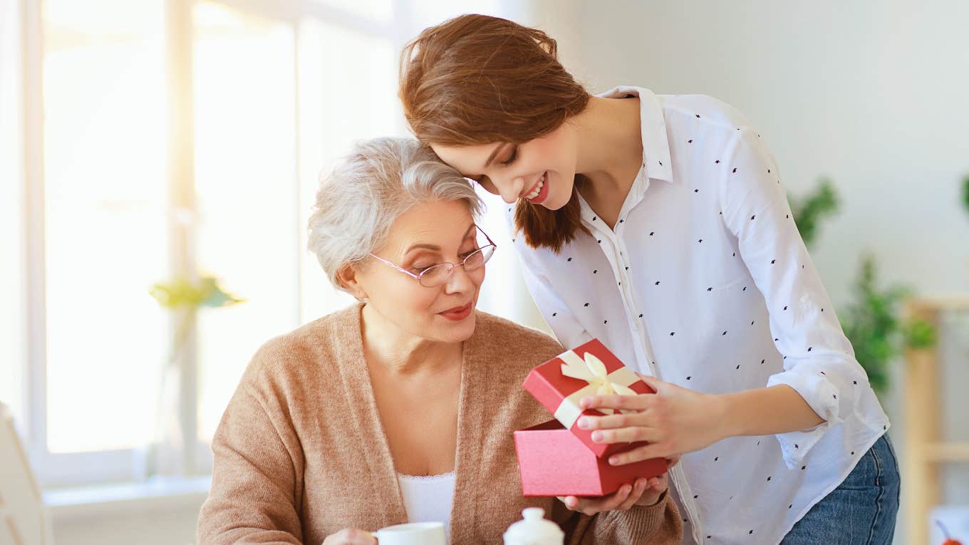 adult daughter giving mother a gift