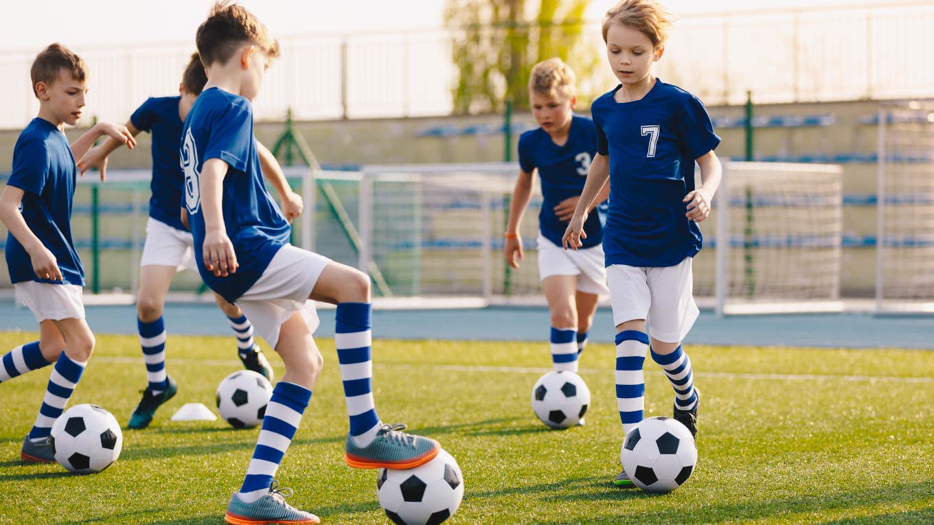 Young kids playing soccer together on a field.