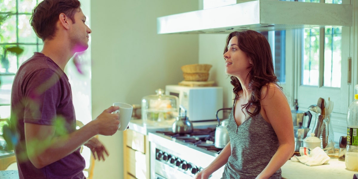 man and woman talking in a kitchen