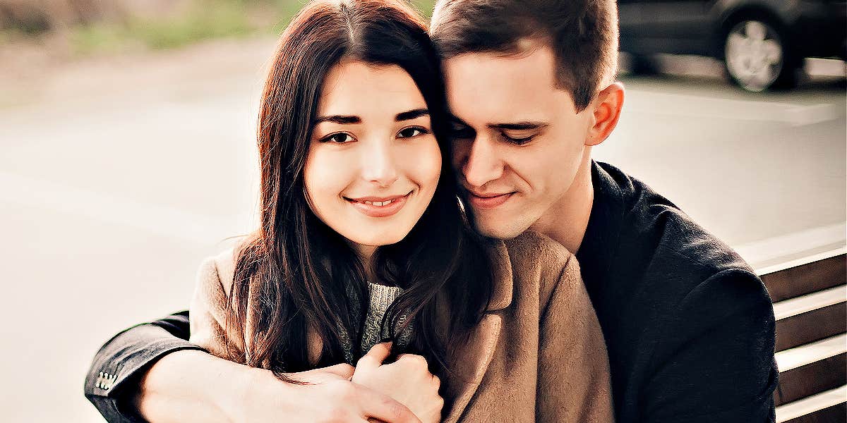Why women give up self-respect for love & how to get it back man and woman on a park bench, man hugging her from behind