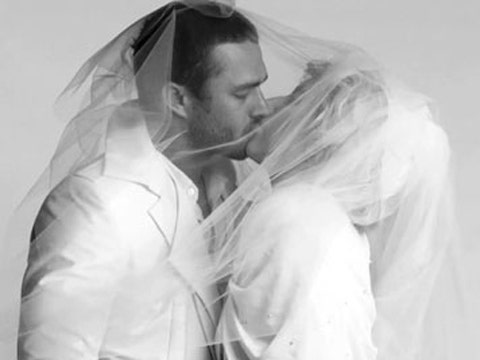 Taylor Kinney and Lady Gaga, rumored to be engaged, kiss under a veil in a black and white wedding-themed photo