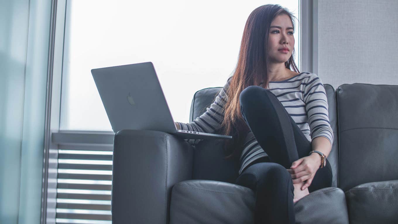 woman sitting on a couch using a laptop