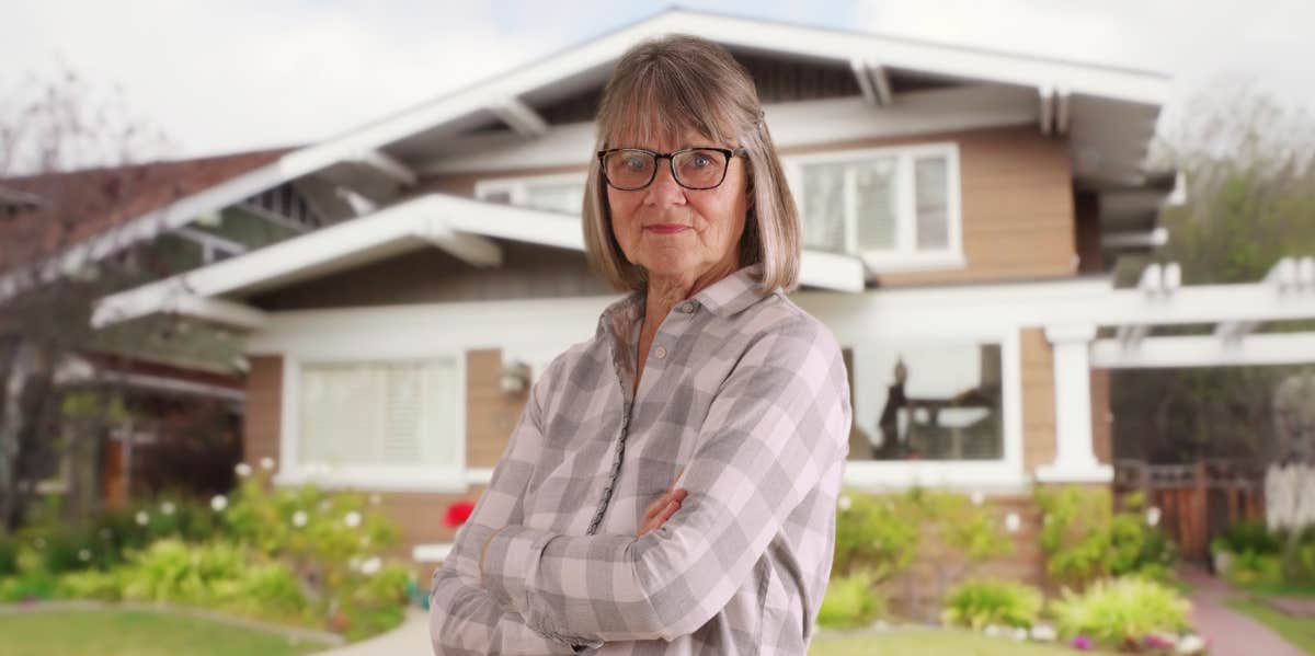 Landlord Tells Tenant He Can't Have Overnight Guests & Receives Backlash woman standing in front of house with arms folded