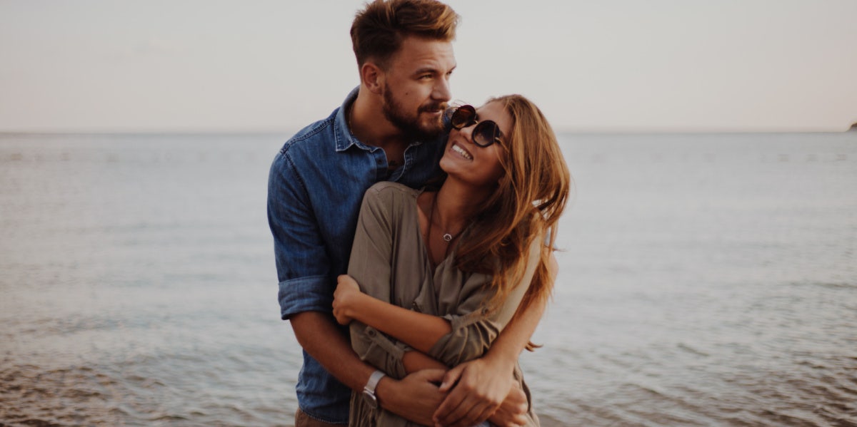 couple embracing by the water on the beach