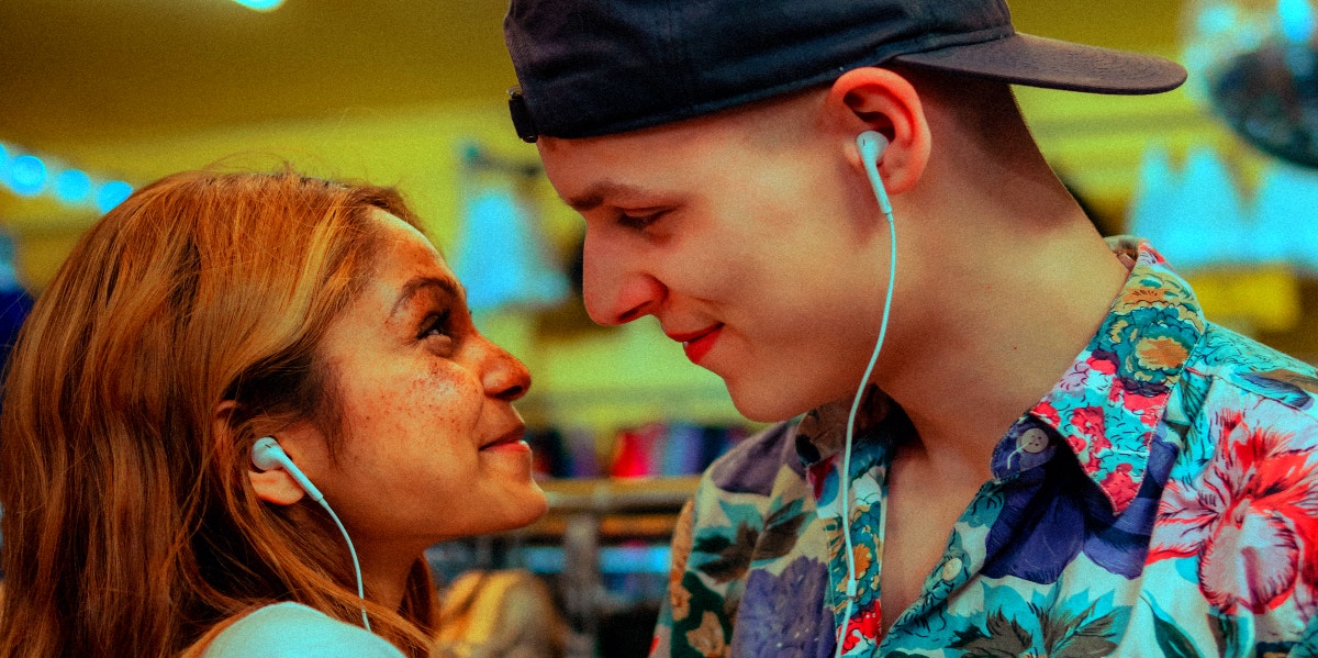 couple staring into each others eyes smiling listening to music