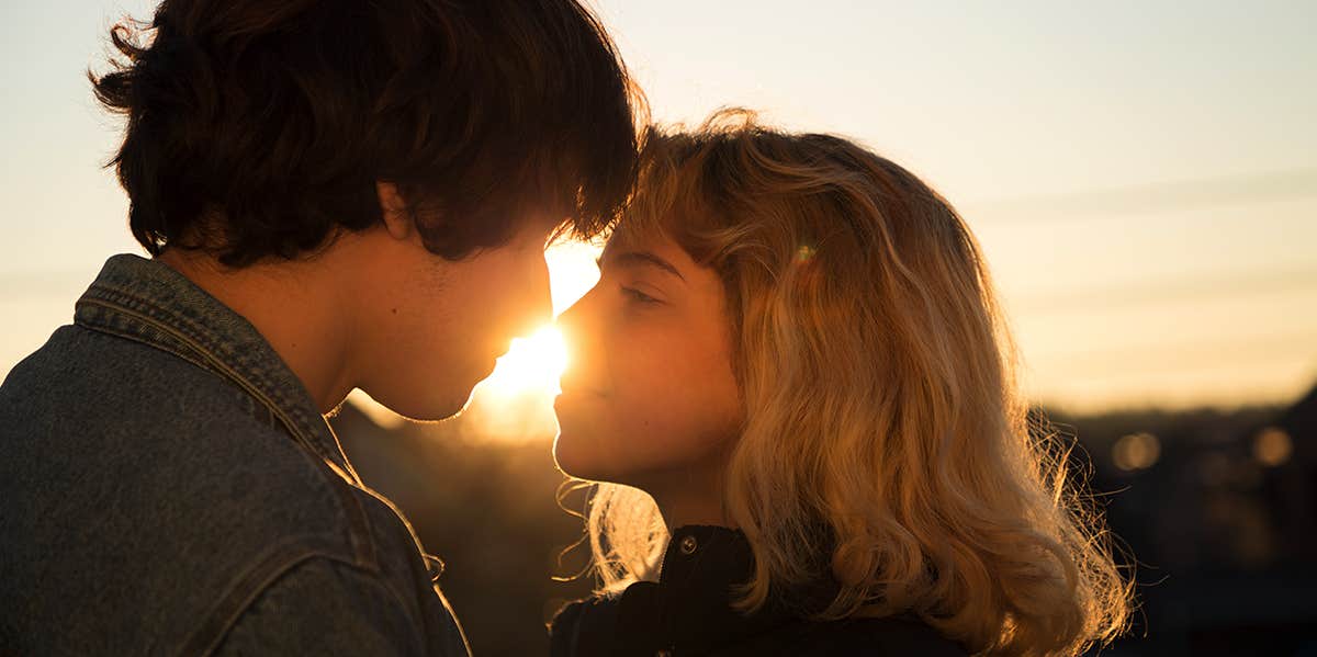 3 Signs You Have "Relationship Anxiety" — And How Not To Spiral couple about to kiss in sunset