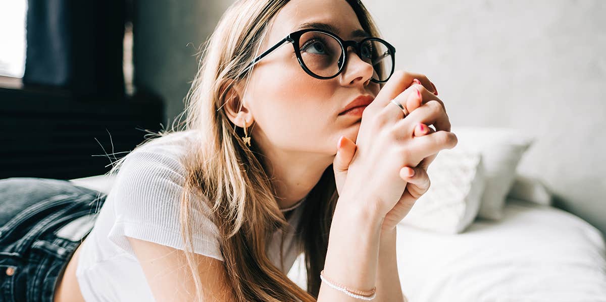 100 Pieces Of Life Advice Everyone Should Know — No Matter Your Age woman laying on bed thinking about life
