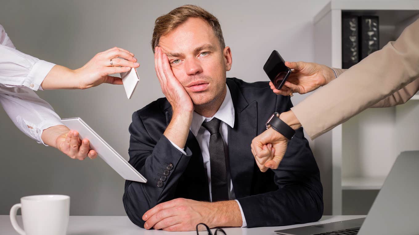 Life Coach Explains The Difference Between Feeling Burnt Out & Having A Burnout Mindset Man looking burnt out and stressed while at work