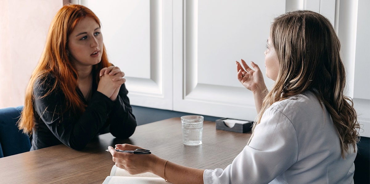 two women chatting together at table