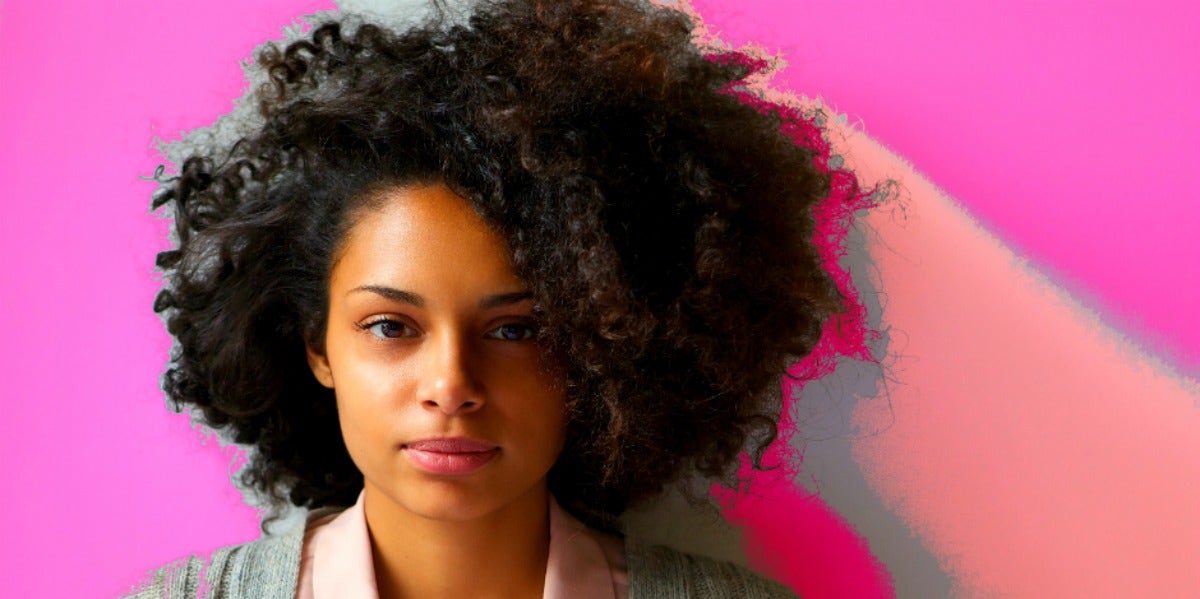 woman with serious face on pink background