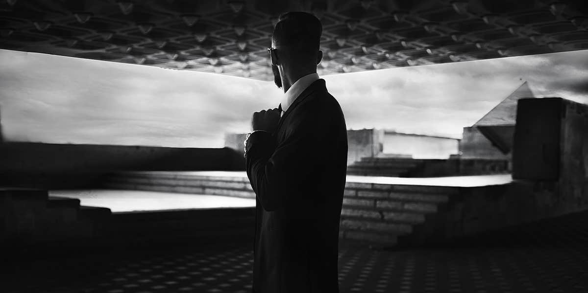man in suit standing in dark area