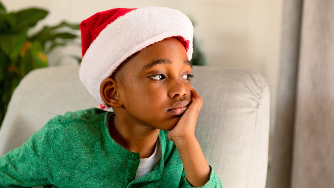 little boy in santa hat sad