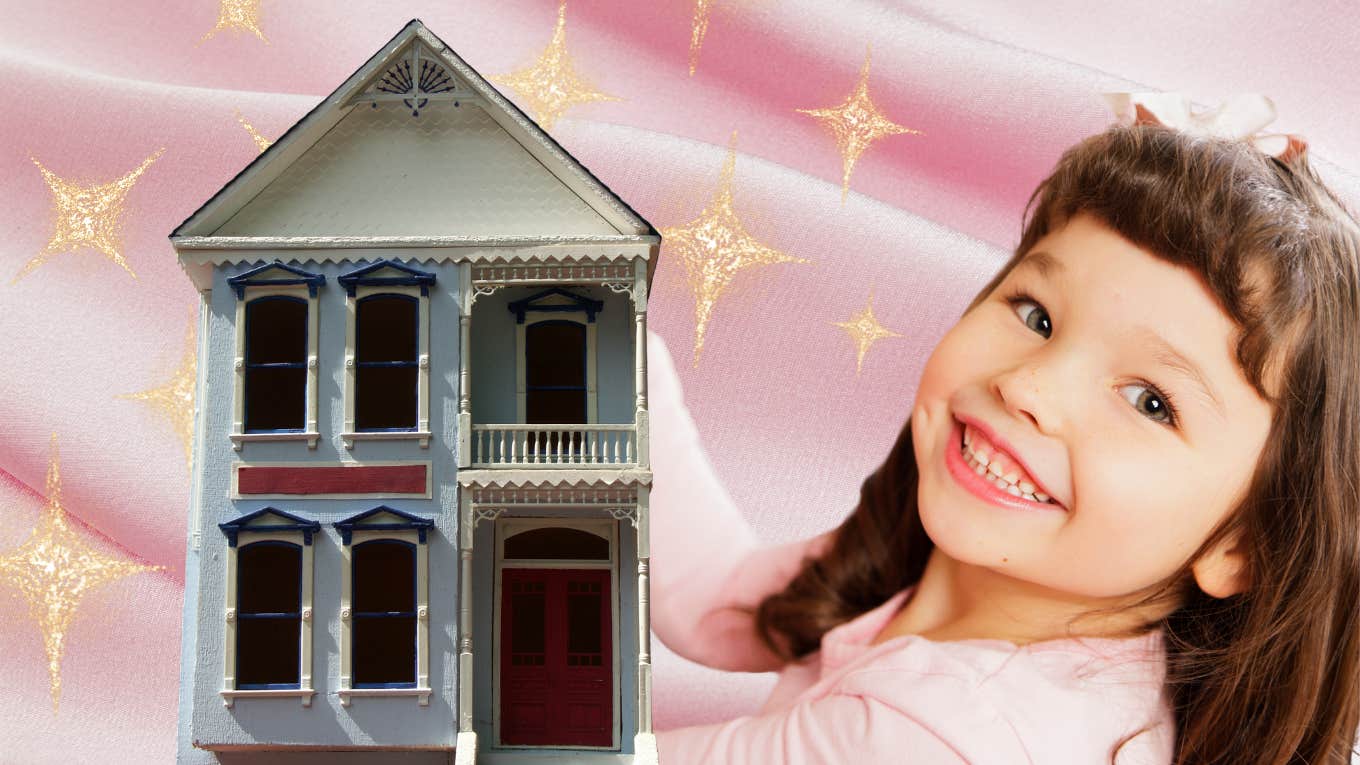 Little girl smiles while playing with a playhouse. 