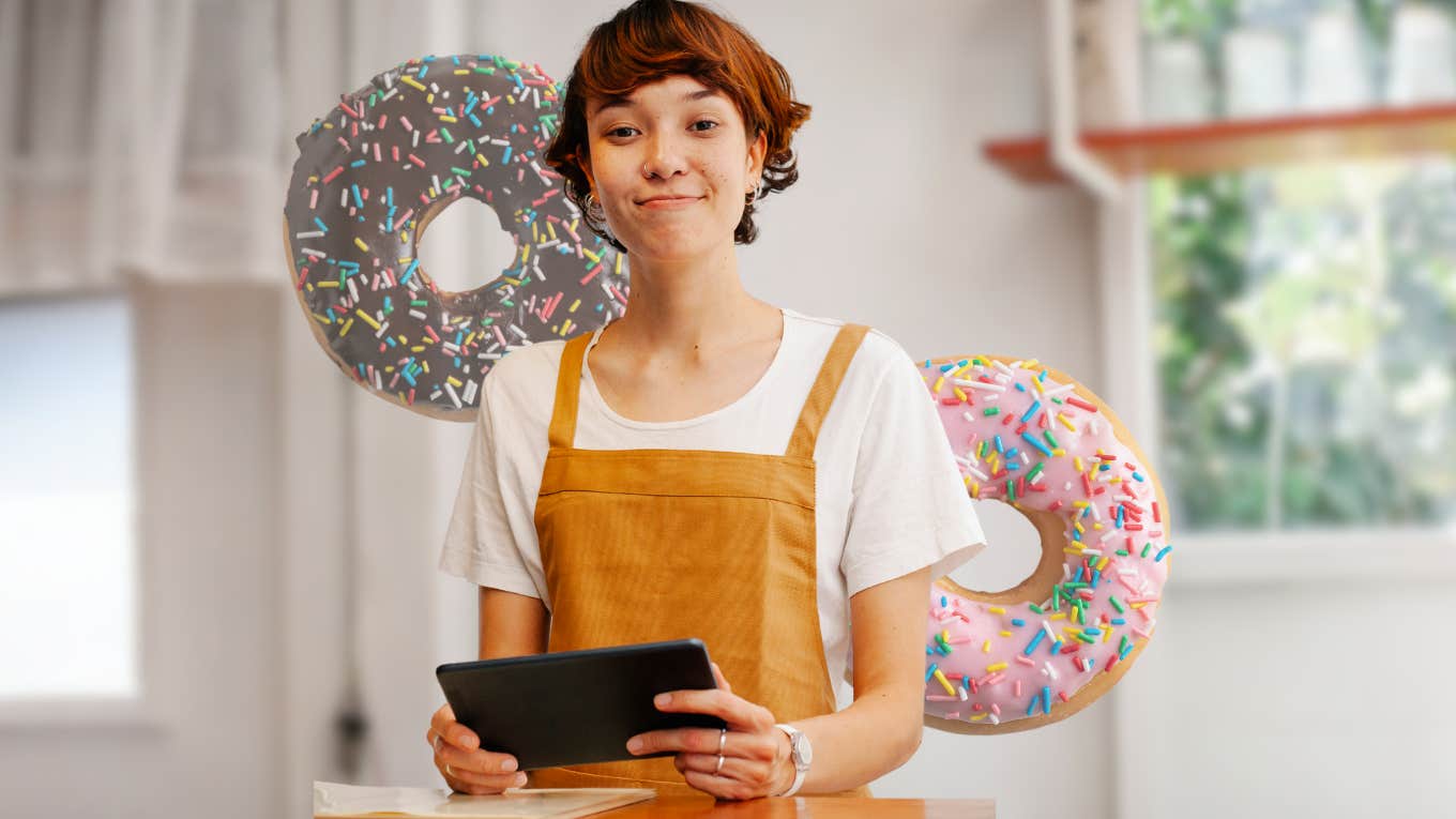 Bakery worker standing in front of donuts