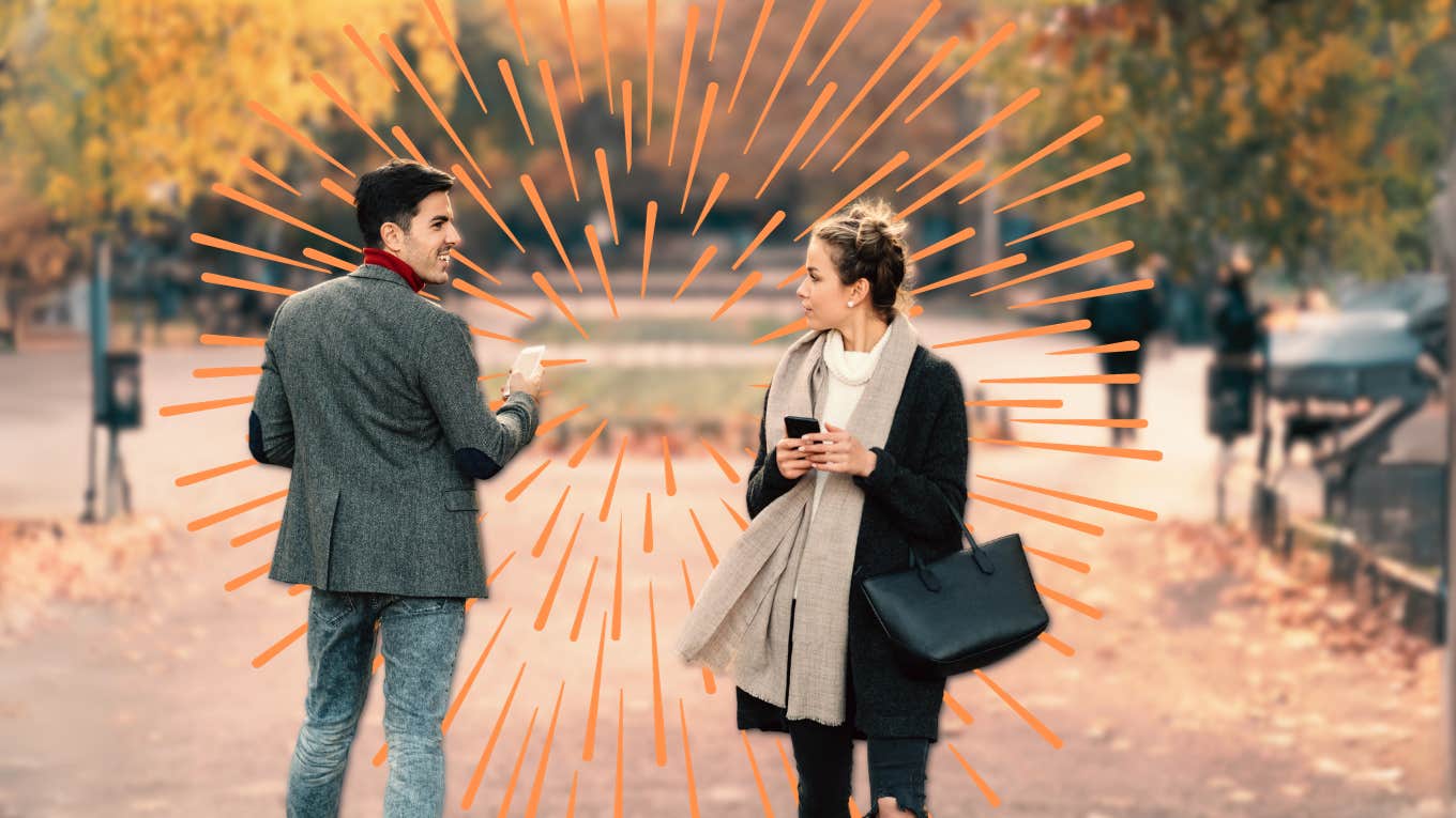 man and woman walking by each other make eye contact and smile