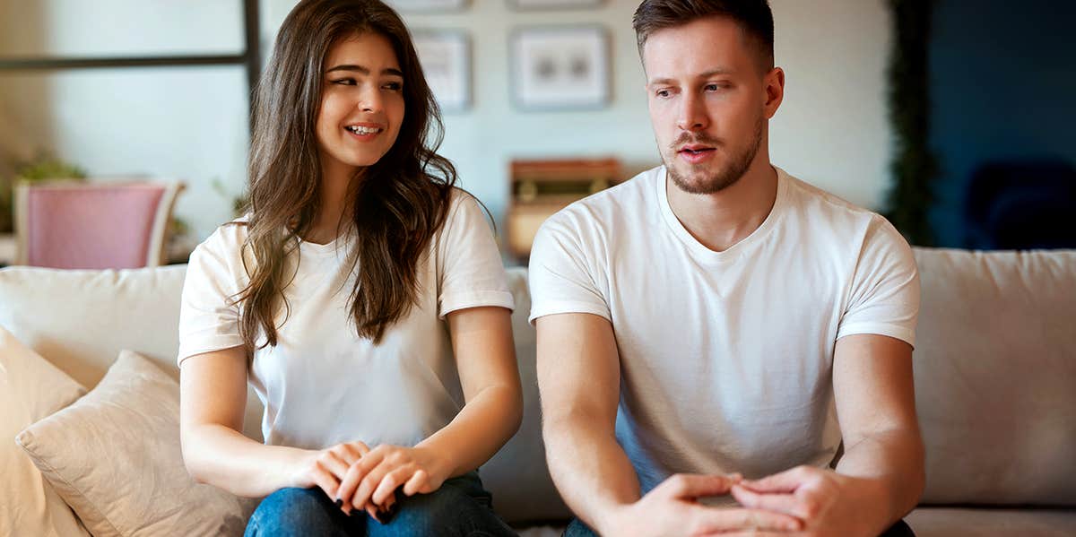 Awkward couple sitting on couch