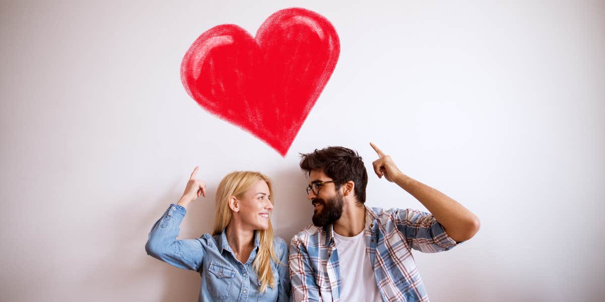 couple pointing at heart