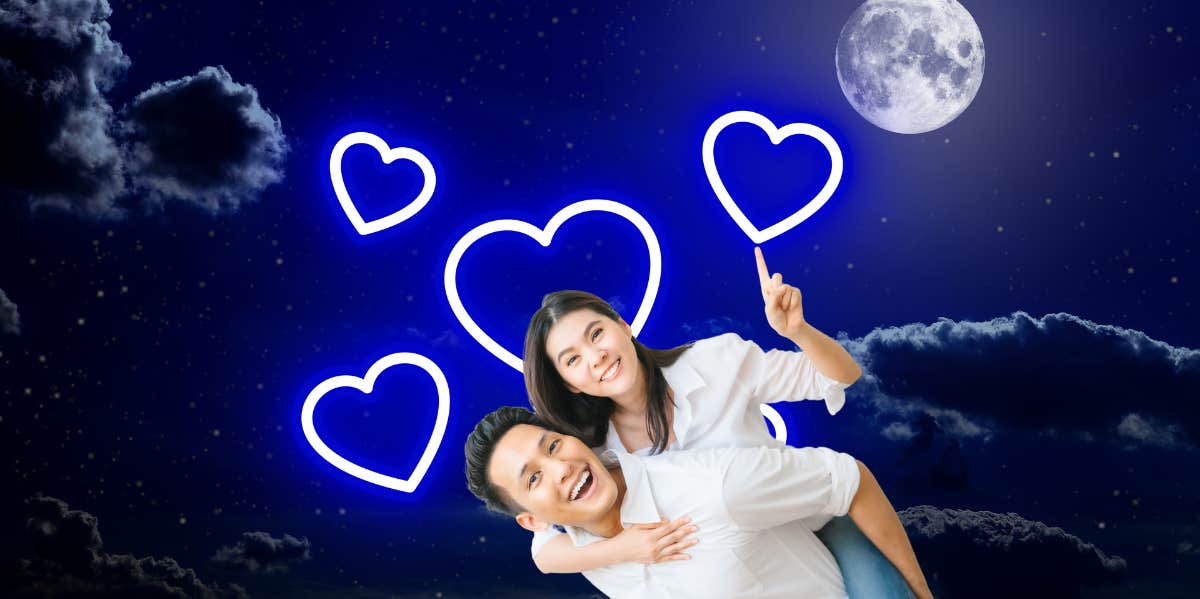 couple smiling in outerspace pointing to blue glowing hearts 