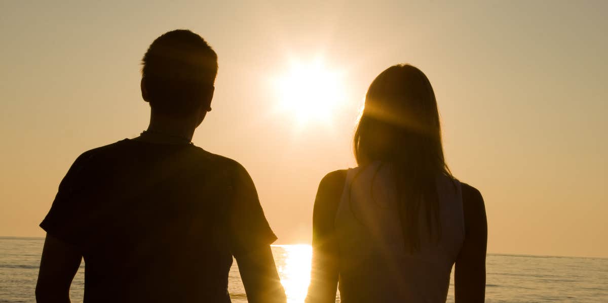 man and woman looking at sun