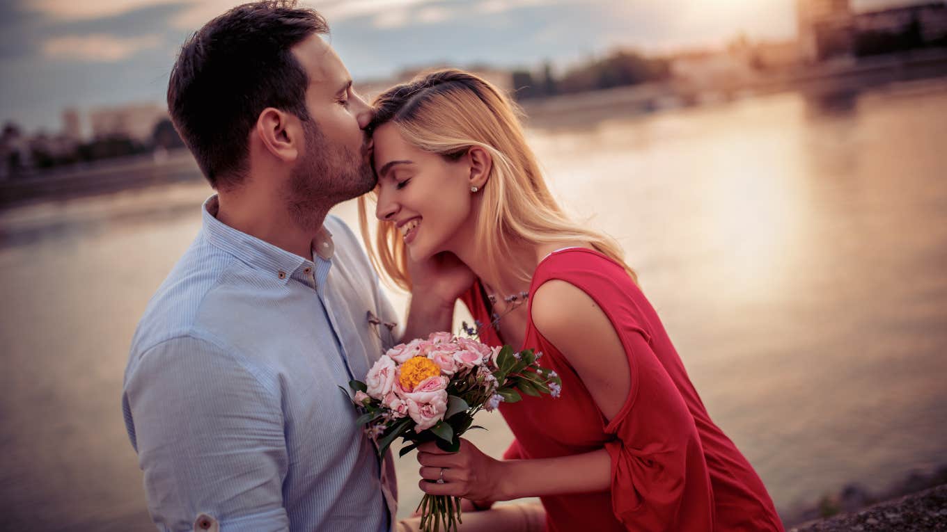 man giving woman a forehead kiss