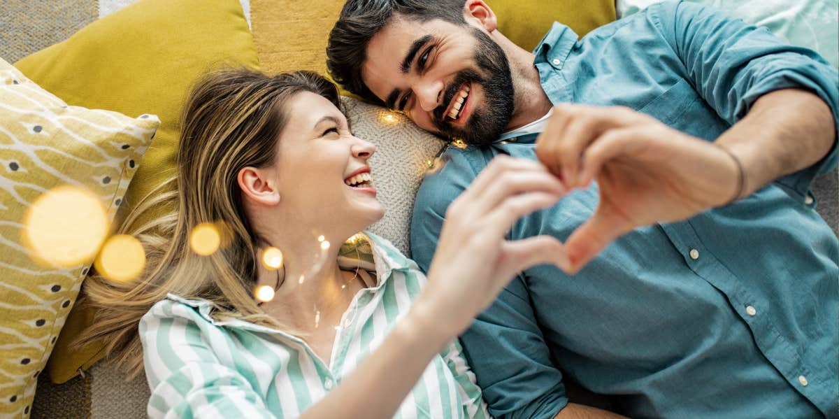 Love Horoscope For November 30, 2023 happy couple making a heart with their hands