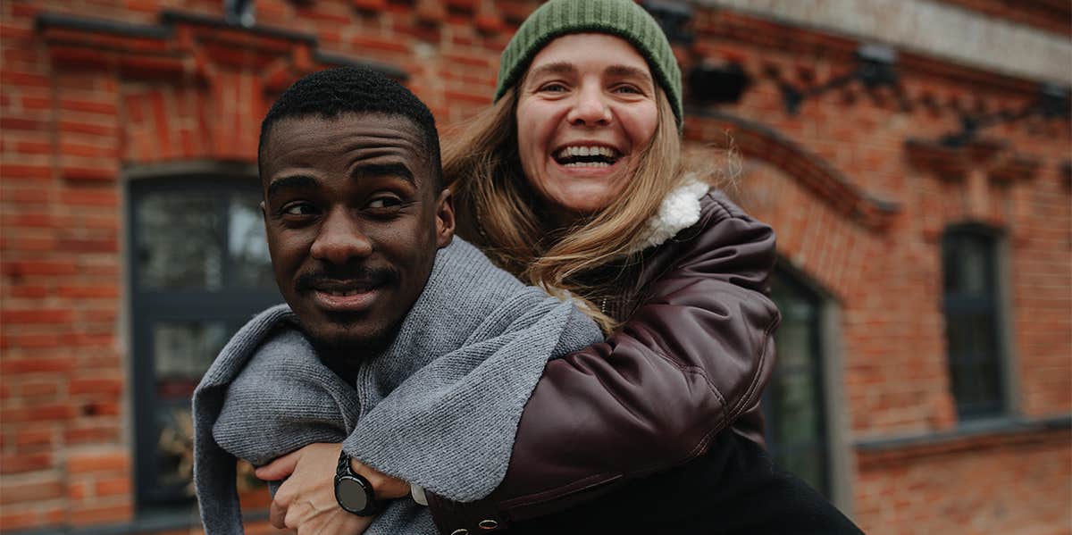 man carrying woman on his back