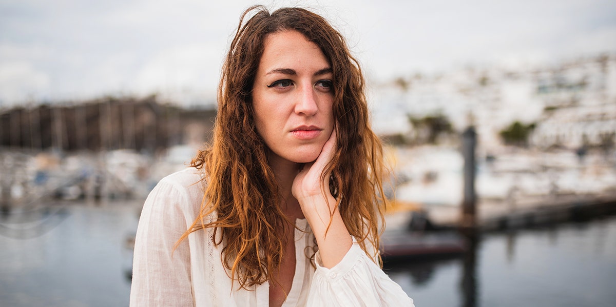 woman looking forlorn with hand on her chin