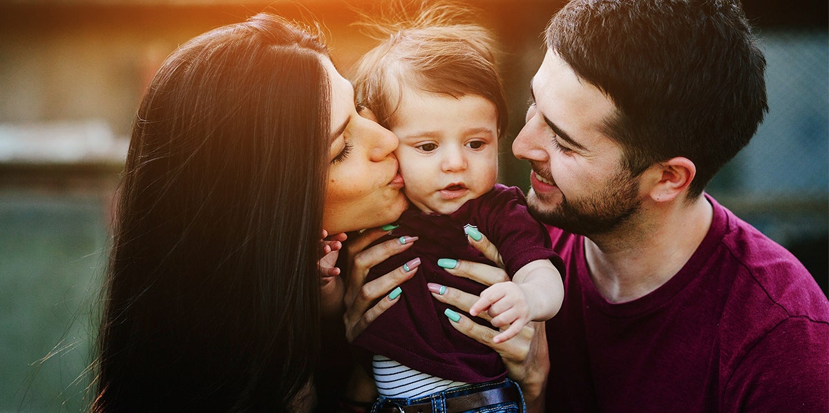 mom and dad holding baby