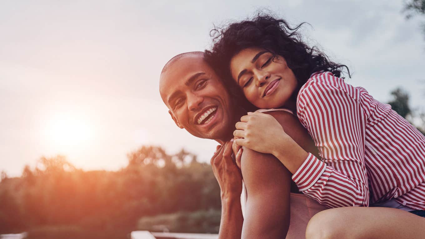 couple holding each other lovingly as the sun sets