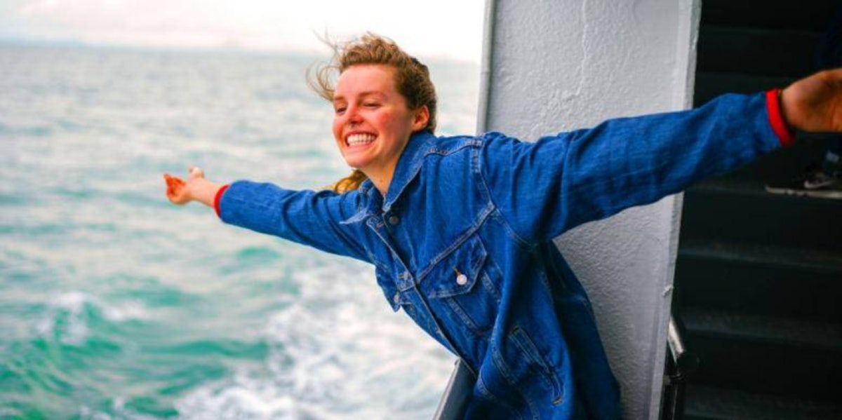 woman smiling off the side of a boat