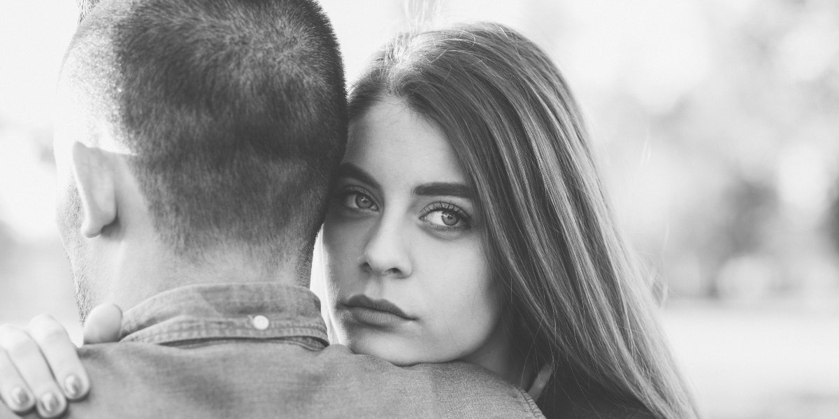 black and white photo of woman hugging man