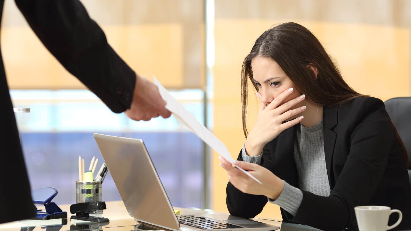 Worried businesswoman receiving a letter from a colleague in her workplace at office