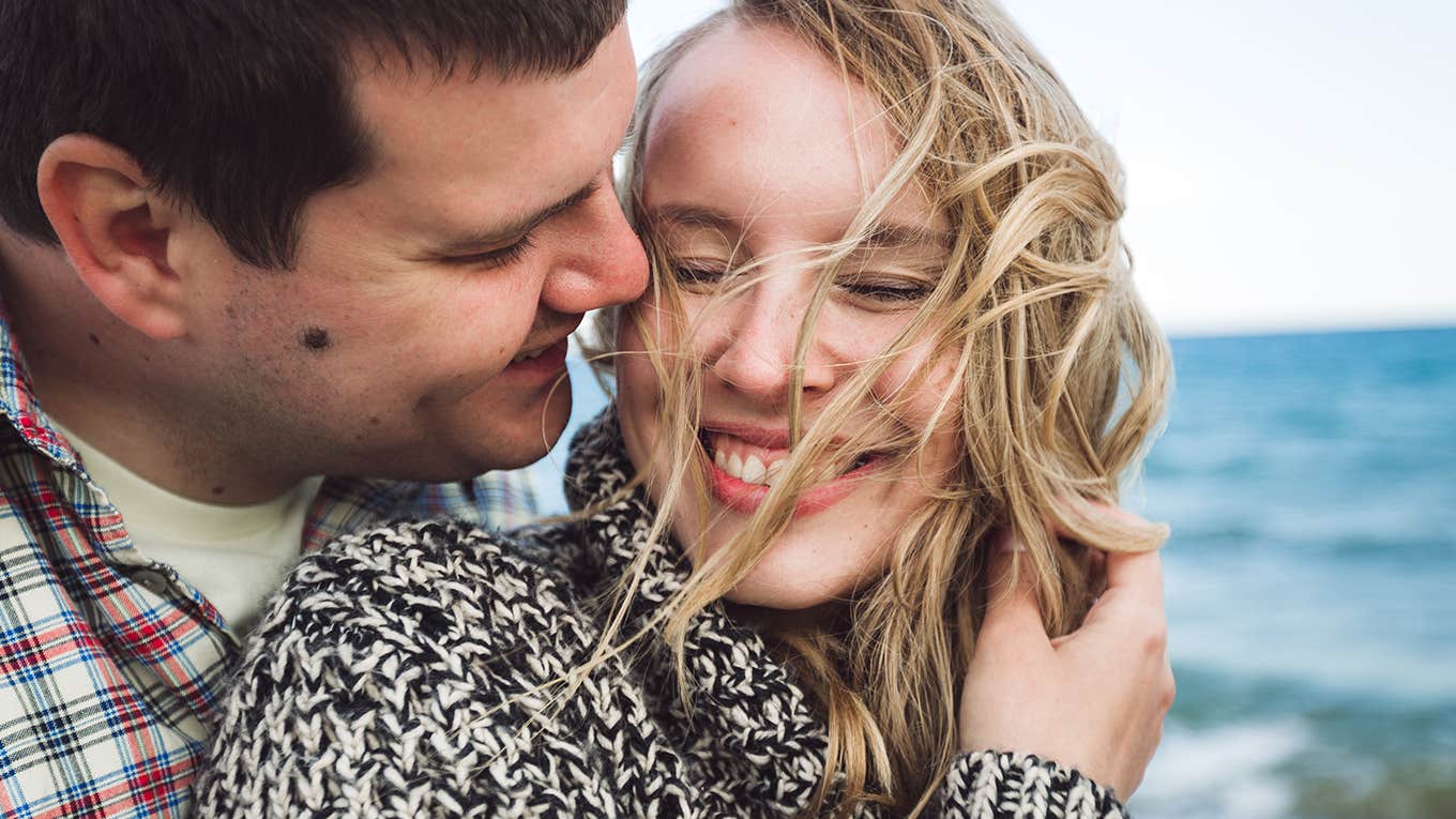 happy couple hugging and smiling on the beach