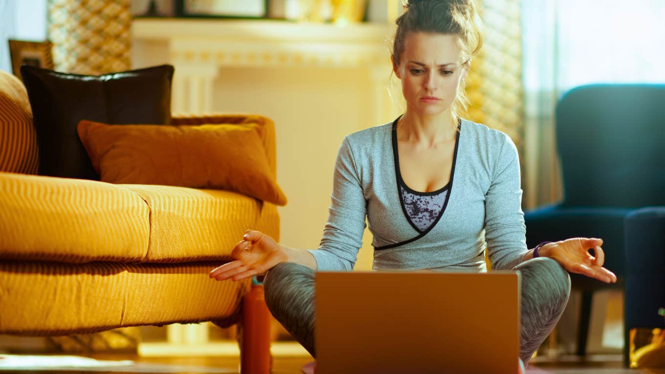 healthy sports woman in fitness clothes in the modern house watching yoga videos on internet via laptop