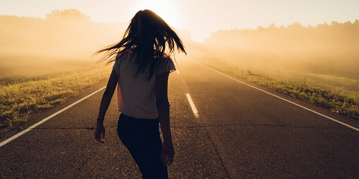 woman running down road in sunset