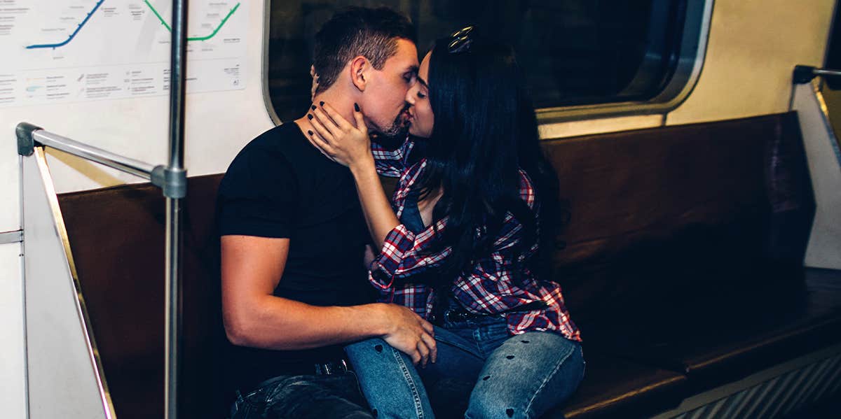 man and woman kissing on subway