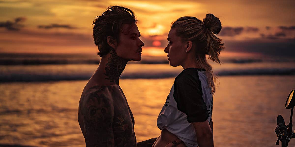 The Male Body Type That Gets The Most Women, Says Study man and woman looking at each other during sunset