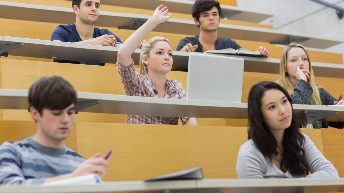 college students in class, one hand raised