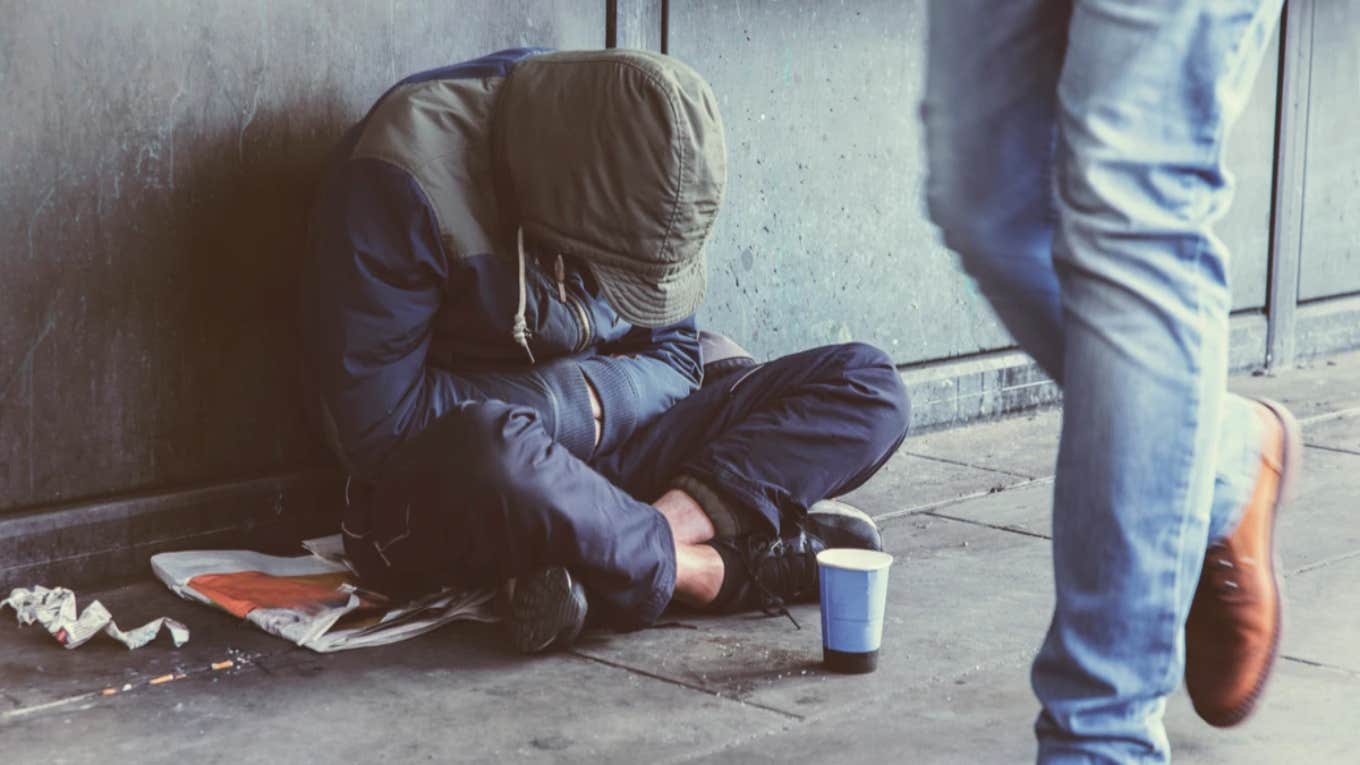 unhoused person with their head down