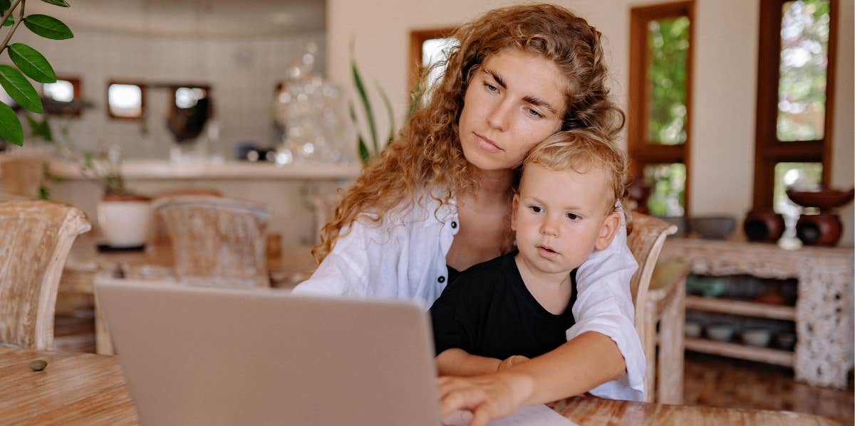 Mom working on computer while holding child